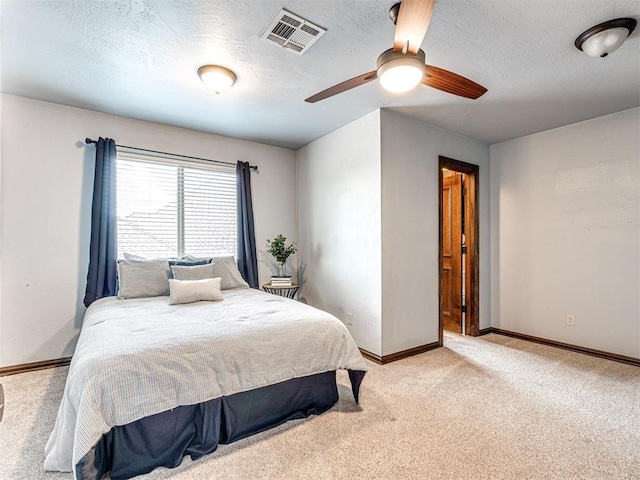 bedroom with light carpet, baseboards, a textured ceiling, and ceiling fan