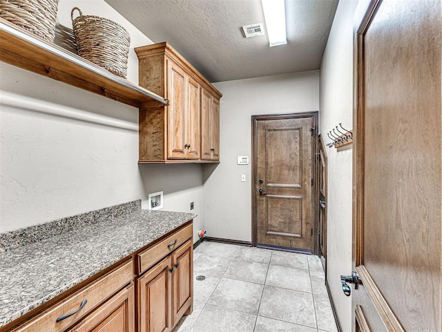 laundry room with hookup for an electric dryer, cabinet space, hookup for a washing machine, baseboards, and light tile patterned floors