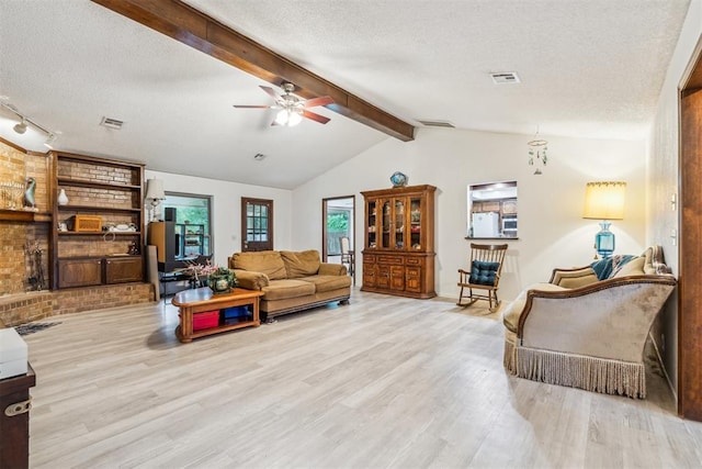 living room featuring wood finished floors, a textured ceiling, ceiling fan, and baseboards