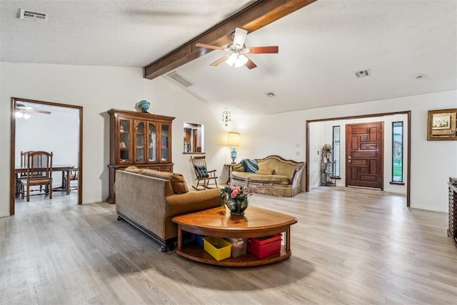 living area with ceiling fan, light wood-style floors, a textured ceiling, and baseboards