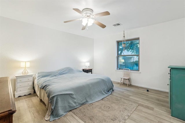 bedroom with light wood-type flooring, a ceiling fan, and baseboards