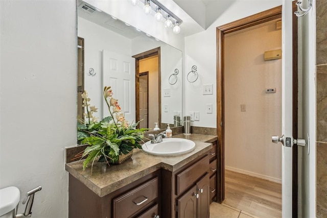 bathroom with vanity, wood finished floors, and toilet