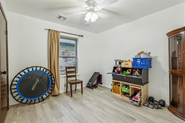 recreation room with wood finished floors, a ceiling fan, and baseboards