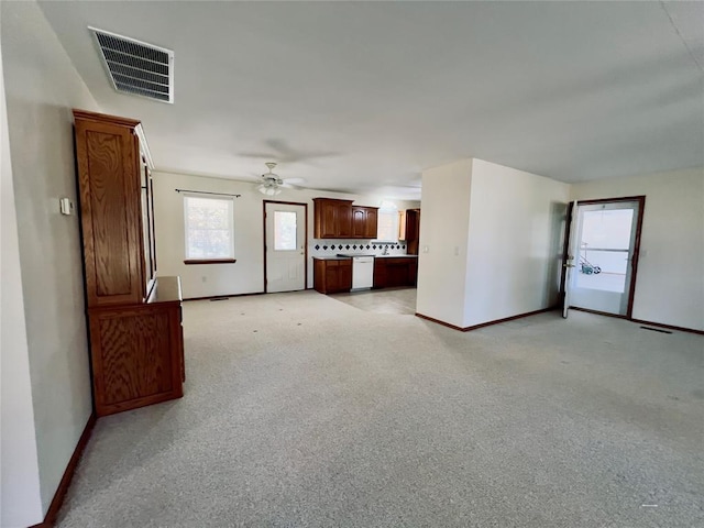 36040 E 1140th Rd Unit 114Rd, Seminole, OK 74868 - unfurnished living room featuring baseboards, a ceiling fan, plenty of natural light, and light carpet