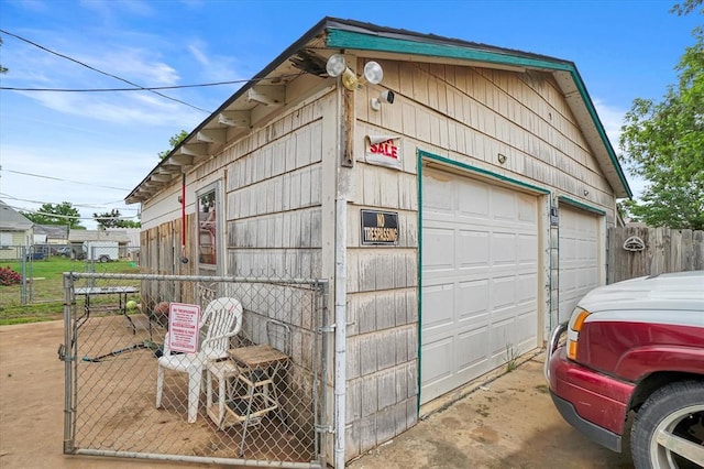 detached garage featuring fence