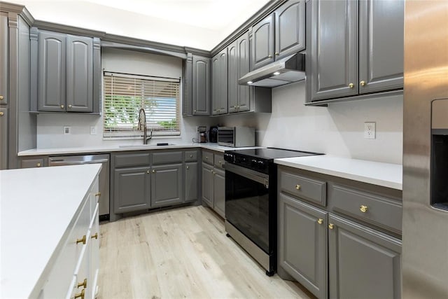 kitchen featuring black range with electric stovetop, under cabinet range hood, a sink, dishwasher, and gray cabinetry