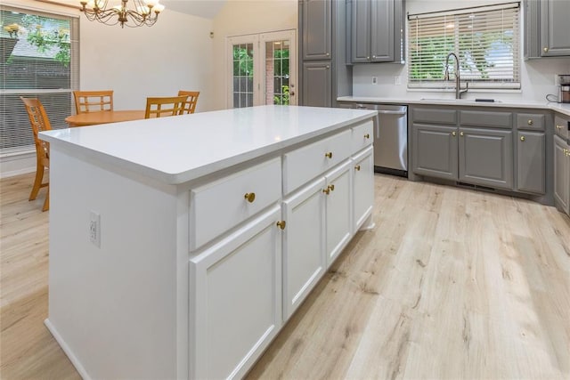 kitchen featuring dishwasher, gray cabinetry, a sink, light wood-style flooring, and french doors