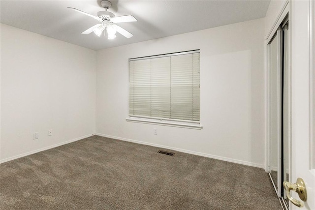 unfurnished bedroom featuring carpet, a closet, baseboards, and ceiling fan
