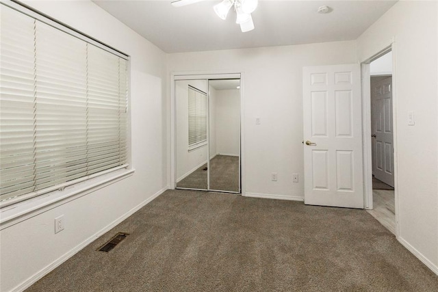 unfurnished bedroom featuring carpet, a closet, baseboards, and a ceiling fan