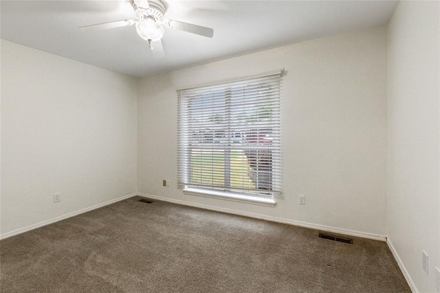 carpeted empty room featuring a ceiling fan and baseboards