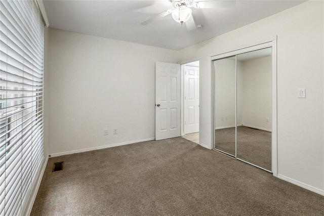 unfurnished bedroom with carpet, a closet, a ceiling fan, and baseboards
