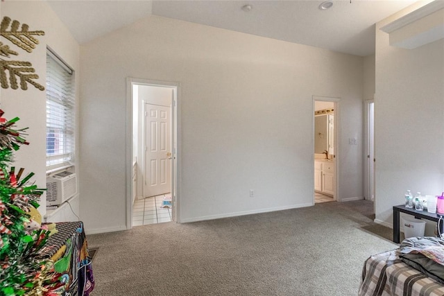 carpeted bedroom with vaulted ceiling, cooling unit, ensuite bathroom, and baseboards