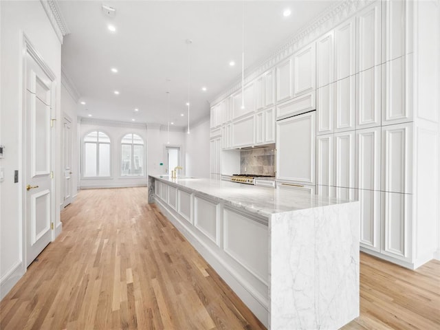 6100 NW Grand Blvd Unit 6103, Oklahoma City, OK 73118 - kitchen featuring recessed lighting, white cabinetry, light wood-type flooring, a large island with sink, and light stone countertops