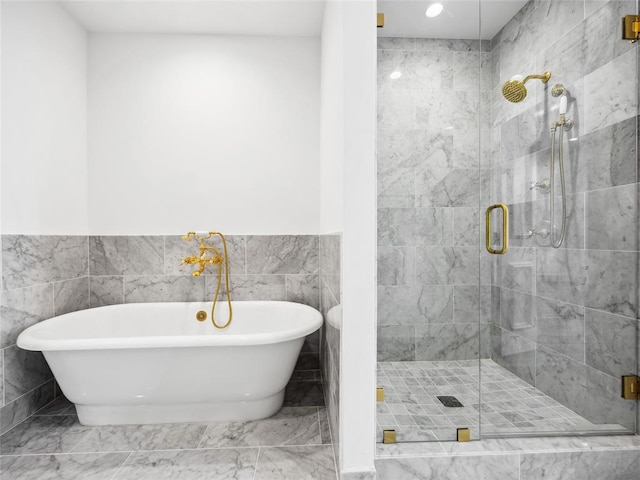 6100 NW Grand Blvd Unit 6103, Oklahoma City, OK 73118 - bathroom featuring a shower stall, a soaking tub, tile walls, marble finish flooring, and wainscoting
