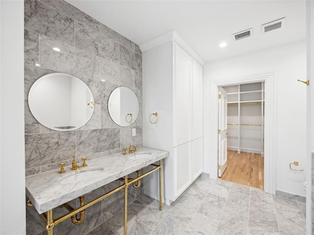 6100 NW Grand Blvd Unit 6103, Oklahoma City, OK 73118 - bathroom featuring double vanity, a walk in closet, and tile walls