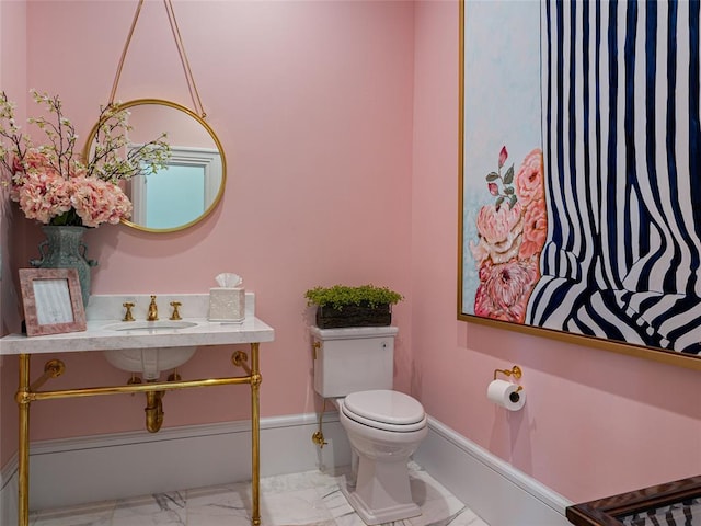 6119 NW Grand Blvd, Oklahoma City, OK 73118 - bathroom with marble finish flooring, toilet, a sink, and baseboards