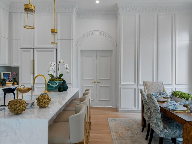 6119 NW Grand Blvd, Oklahoma City, OK 73118 - dining room featuring light wood-style flooring, a decorative wall, crown molding, and recessed lighting