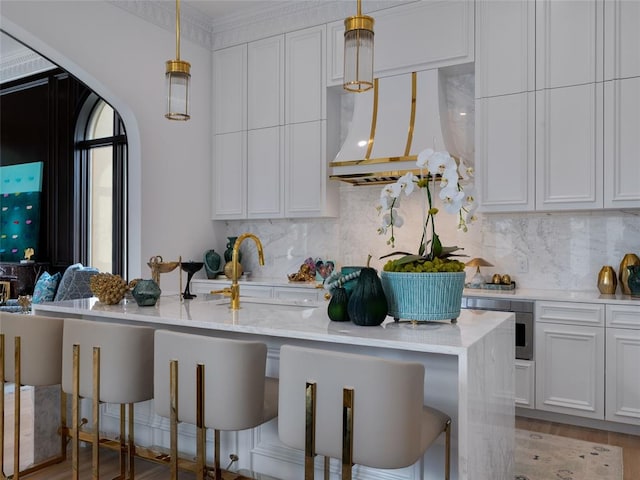 6119 NW Grand Blvd, Oklahoma City, OK 73118 - kitchen featuring custom range hood, a kitchen breakfast bar, decorative backsplash, pendant lighting, and white cabinetry