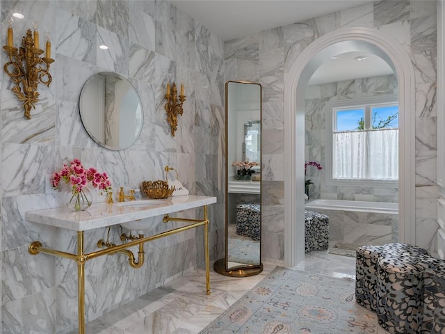 6119 NW Grand Blvd, Oklahoma City, OK 73118 - bathroom with marble tiled floors, tile walls, and a garden tub