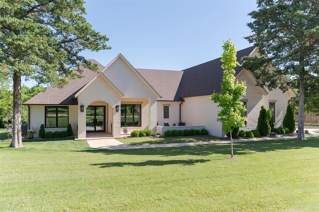 view of front of property featuring a front yard and roof with shingles