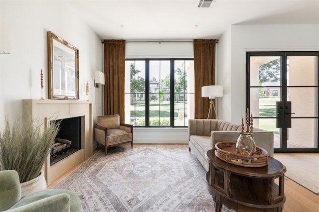 living area with french doors, a fireplace, and baseboards