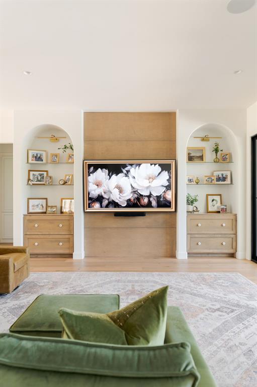 living room with built in features and wood finished floors