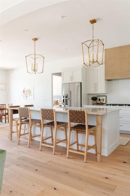kitchen featuring a chandelier, high quality fridge, light wood-style flooring, and recessed lighting