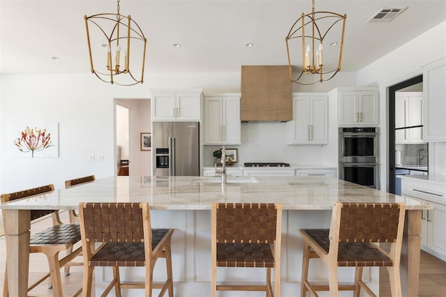kitchen featuring stainless steel appliances, a chandelier, a sink, decorative light fixtures, and recessed lighting