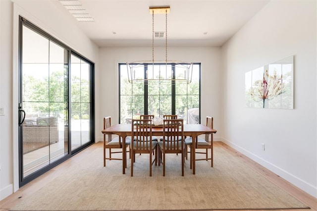 dining room featuring plenty of natural light, light wood-style floors, and baseboards