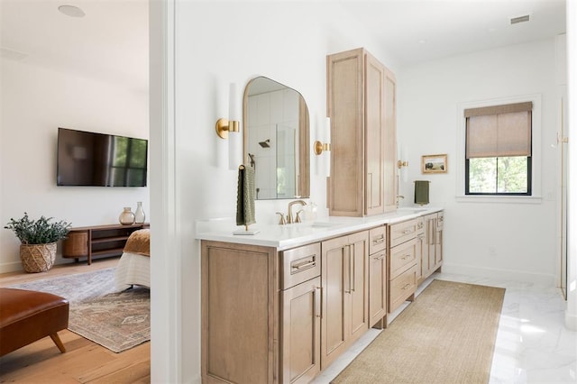 bathroom featuring double vanity, baseboards, and connected bathroom