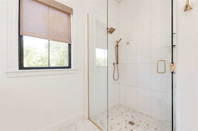 full bath with a shower stall, baseboards, and marble finish flooring