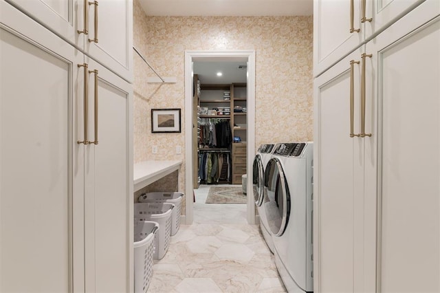laundry area with cabinet space, independent washer and dryer, and light marble finish floors