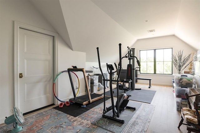 exercise room with vaulted ceiling, wood finished floors, and baseboards