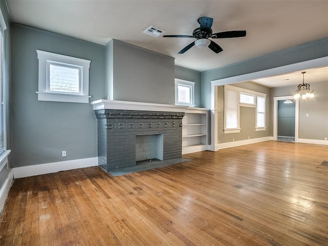 unfurnished living room featuring a fireplace, baseboards, wood finished floors, and a ceiling fan