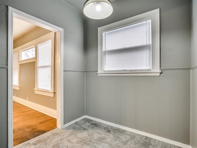 unfurnished room with baseboards