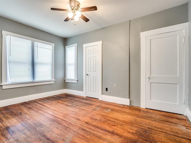unfurnished bedroom featuring baseboards, wood finished floors, and a ceiling fan