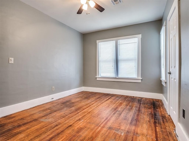 unfurnished room featuring wood finished floors, a ceiling fan, and baseboards