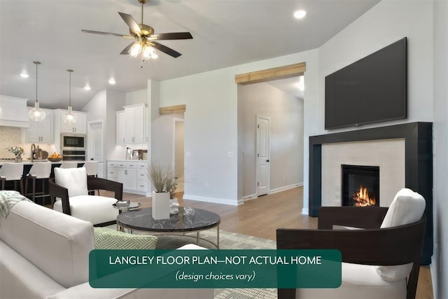 living room featuring light wood-type flooring, ceiling fan, lofted ceiling, a lit fireplace, and baseboards