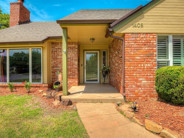 1409 Echohollow Trl, Edmond, OK 73025 - entrance to property featuring brick siding, a chimney, and a shingled roof