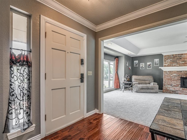 1409 Echohollow Trl, Edmond, OK 73025 - foyer entrance featuring dark wood finished floors, crown molding, a fireplace, and baseboards