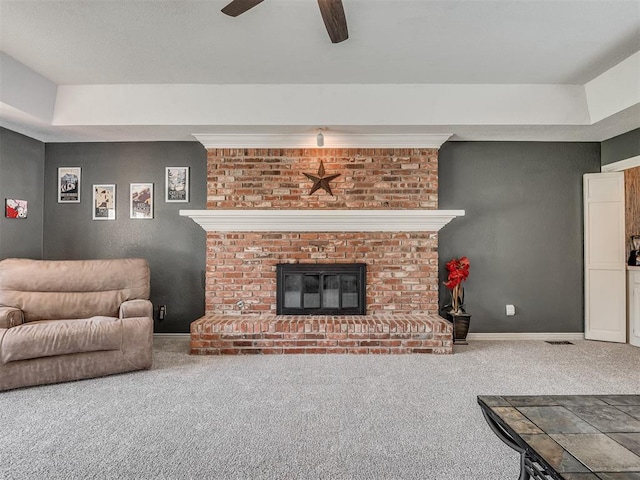 1409 Echohollow Trl, Edmond, OK 73025 - living room featuring carpet floors, ceiling fan, baseboards, and a fireplace