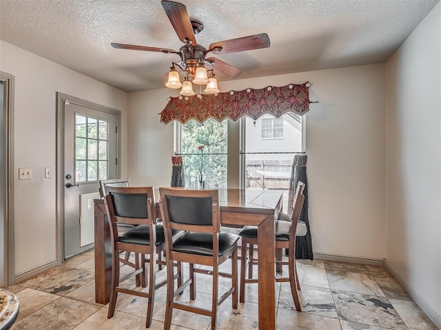 1409 Echohollow Trl, Edmond, OK 73025 - dining area featuring a textured ceiling, ceiling fan, and baseboards