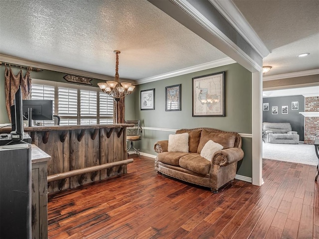 1409 Echohollow Trl, Edmond, OK 73025 - living room with a textured ceiling, a chandelier, ornamental molding, dark wood finished floors, and baseboards