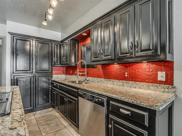 1409 Echohollow Trl, Edmond, OK 73025 - kitchen with dishwasher, tasteful backsplash, dark cabinets, a textured ceiling, and light stone counters