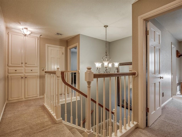 1409 Echohollow Trl, Edmond, OK 73025 - corridor featuring light colored carpet, an upstairs landing, a textured ceiling, and a chandelier