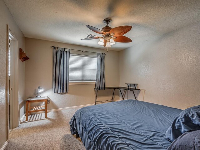 1409 Echohollow Trl, Edmond, OK 73025 - bedroom featuring a textured wall, carpet floors, a textured ceiling, and ceiling fan