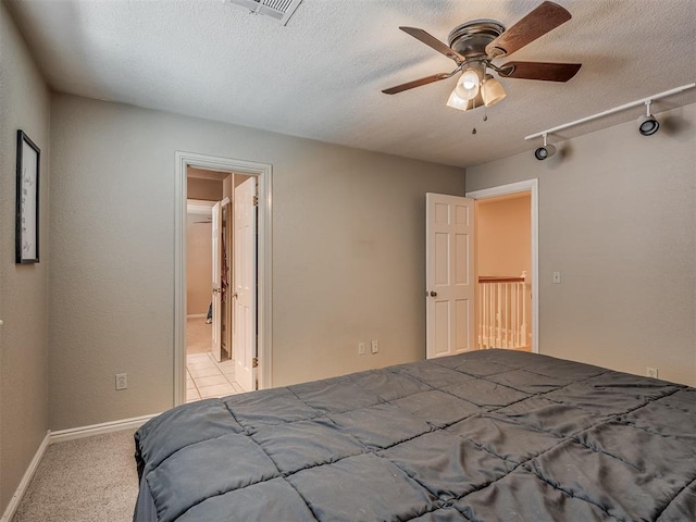 1409 Echohollow Trl, Edmond, OK 73025 - bedroom with carpet floors, a textured ceiling, ensuite bathroom, and a ceiling fan