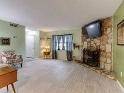 2624 N Ann Arbor St Unit 106, Oklahoma City, OK 73127 - living room featuring a stone fireplace