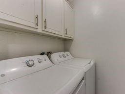 2624 N Ann Arbor St Unit 106, Oklahoma City, OK 73127 - laundry area featuring washing machine and clothes dryer and cabinet space