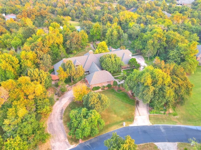 aerial view of property and surrounding area featuring a heavily wooded area